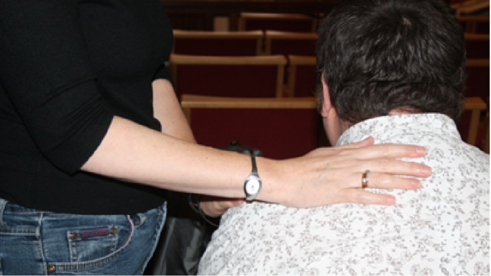 image of hand on a man's shoulder